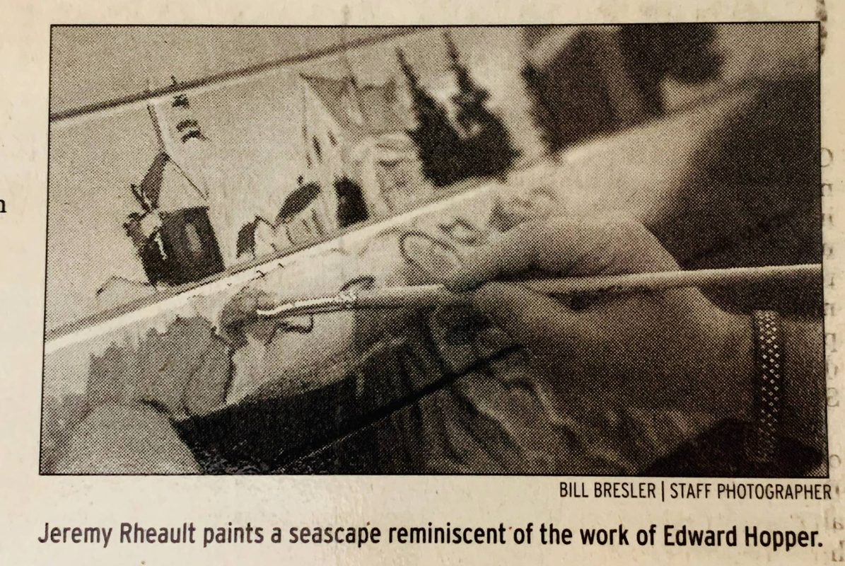Close-up of Jeremy Rheault painting the bench with a brush