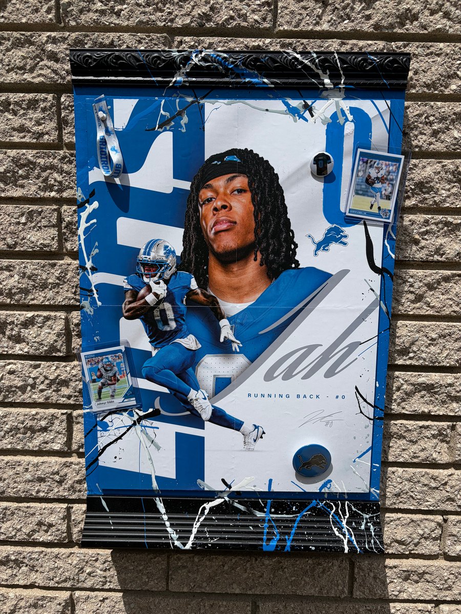 Hand-embellished Detroit Lions player poster on a brick wall