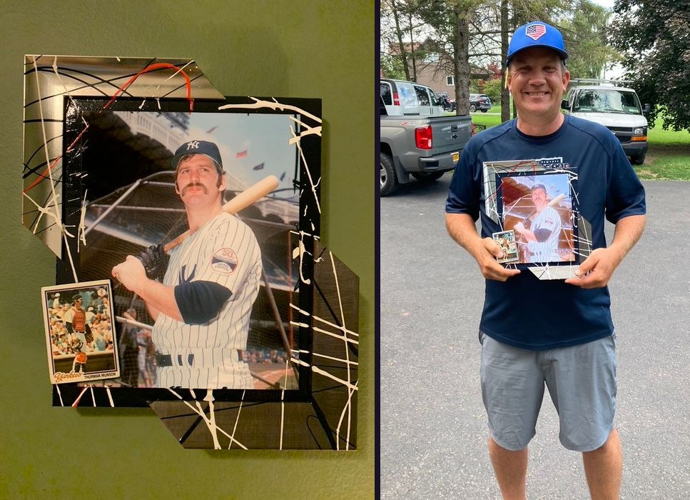 Hand-embellished Thurman Munson New York Yankees photo with a trading card in a silver and black splatter-painted frame, and held by a customer