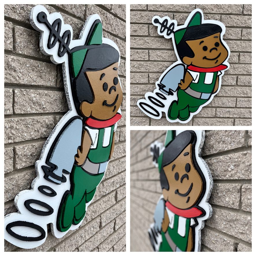 Custom retro cartoon jetpack kid cutout in green, red and white on a brick wall: angled side view, front view and a close-up of the layers