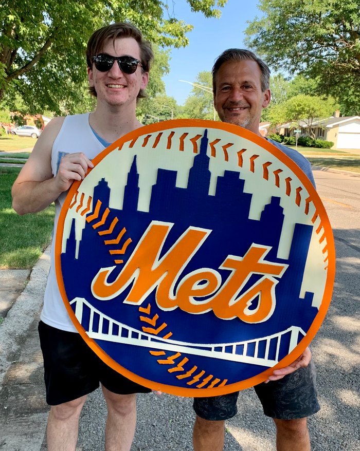 Custom New York Mets logo cutout, held by two customers