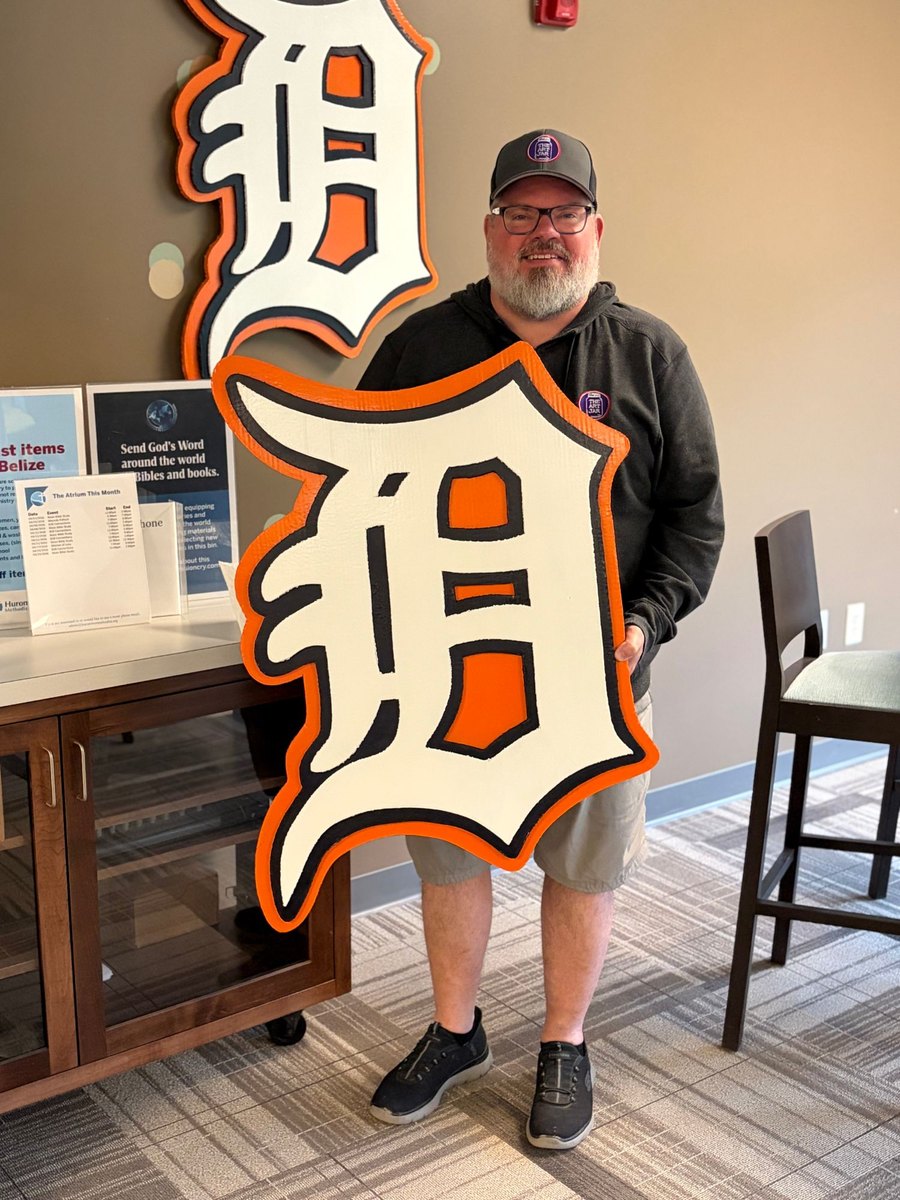 Jeremy holding a custom orange Detroit Tigers Old English D cutout beside a larger D on the wall