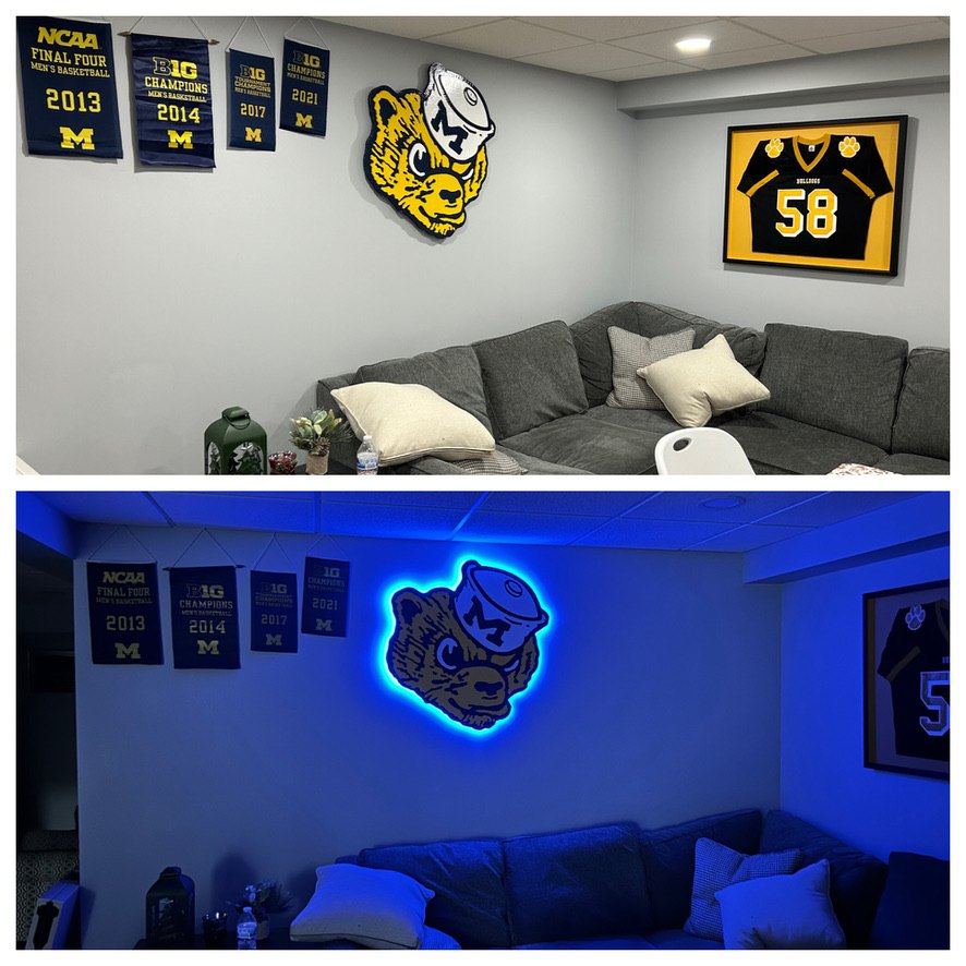 Custom vintage Michigan Wolverine cutout in a basement lounge with Michigan banners, shown in daylight and glowing with blue LED backlighting at night