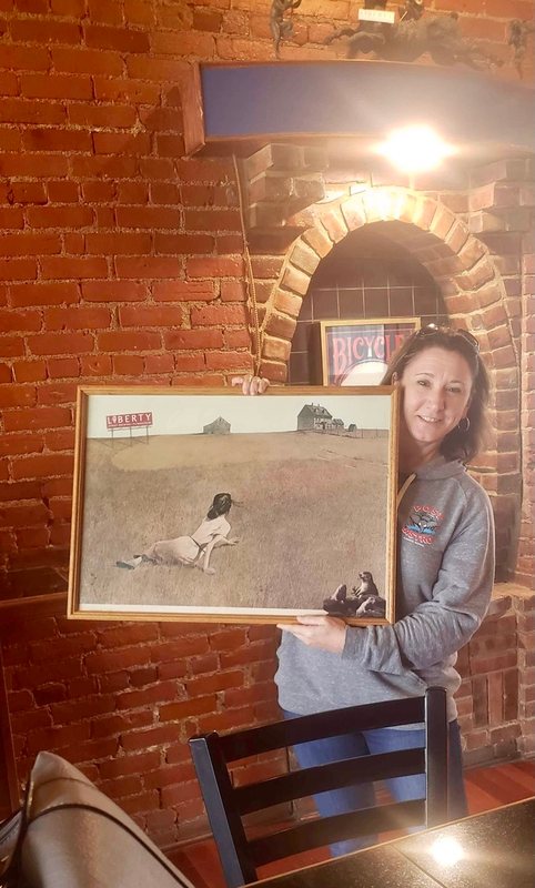 The buyer holding Christina’s Liberty in a brick-walled room at Liberty Street Brewing Company