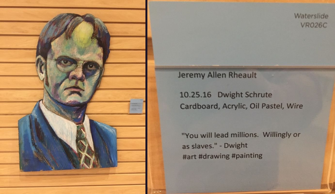 Painted cardboard portrait of Dwight Schrute next to its blue gallery card