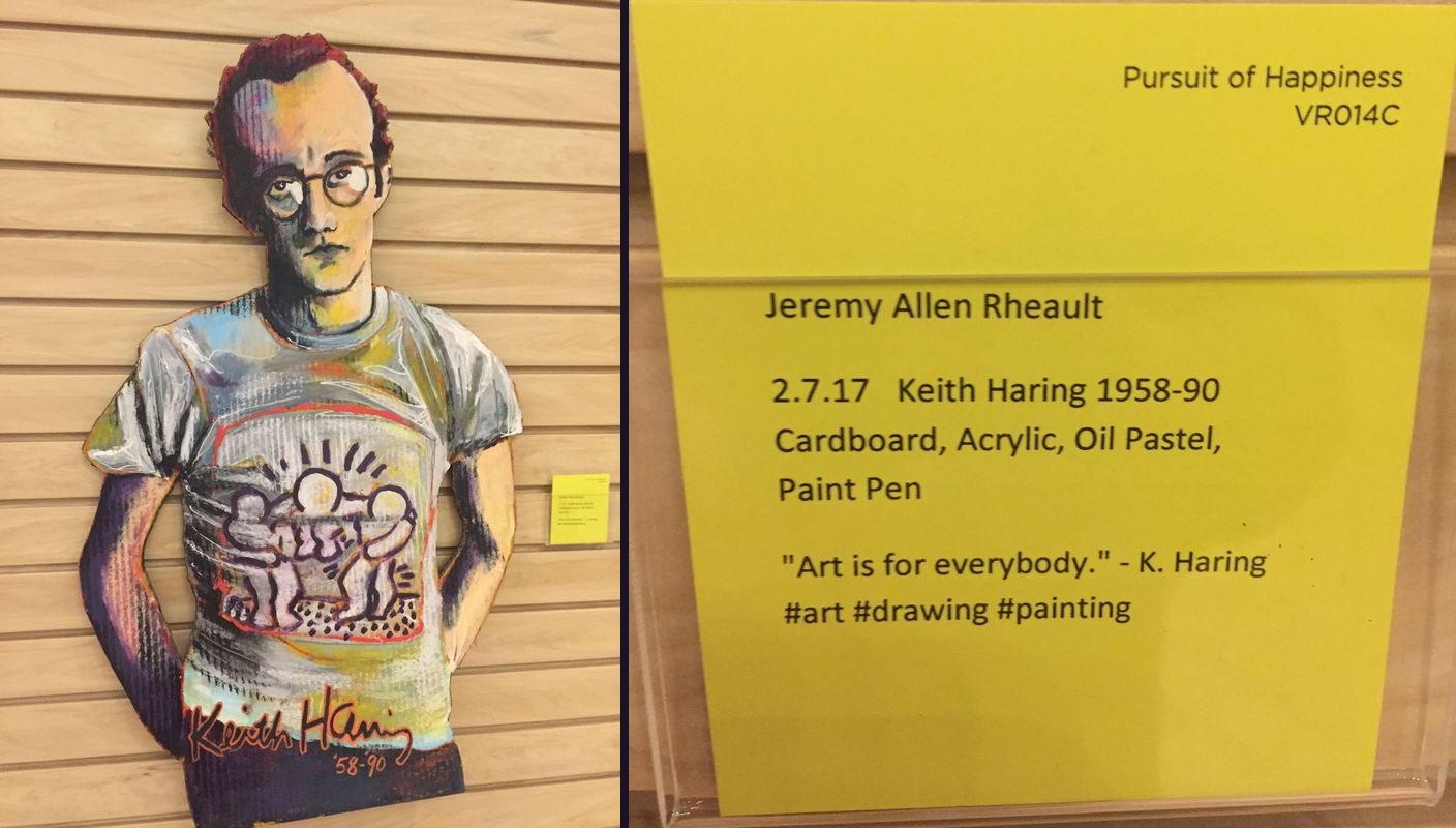 Painted cardboard portrait of Keith Haring next to its yellow gallery card