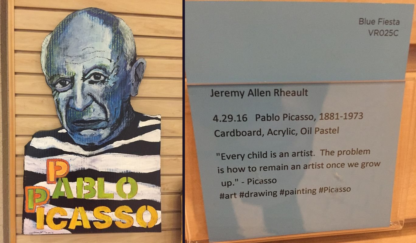 Painted cardboard portrait of Picasso in a striped shirt next to its blue gallery card