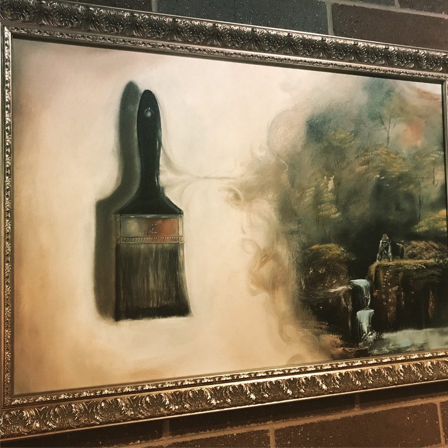 Large framed painting of a paintbrush whose bristles dissolve into a misty waterfall landscape