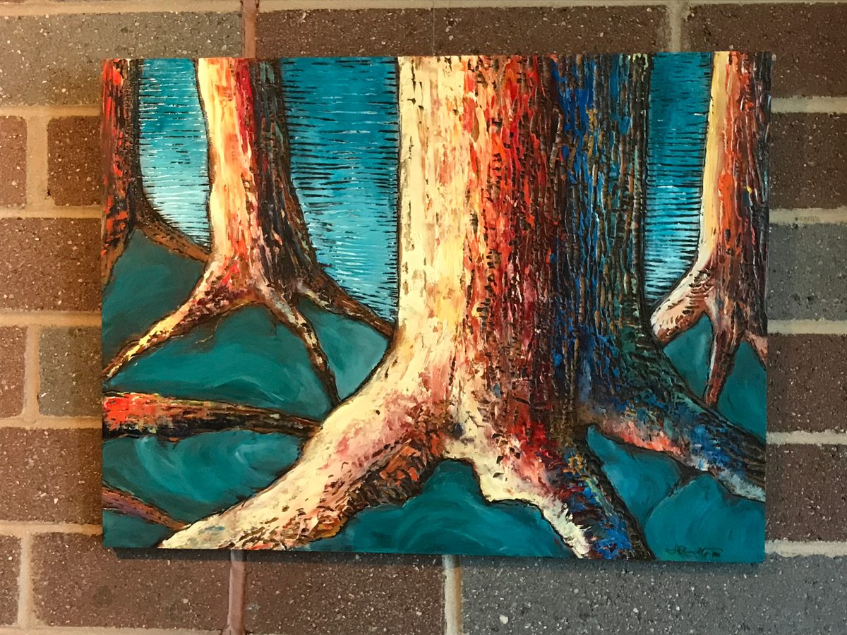 Painting of tree roots in orange, red and white against a teal background, hung on a brick wall