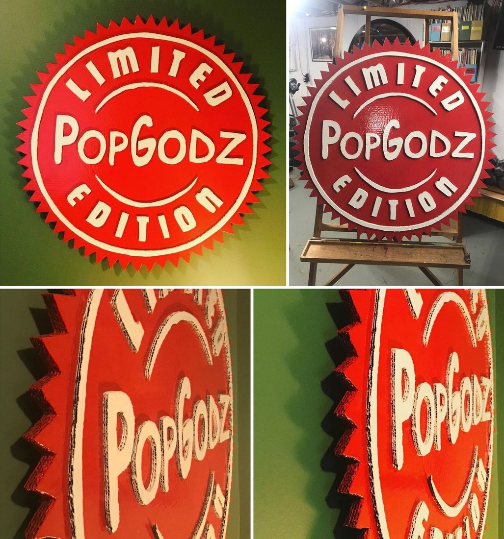 The red and white PopGodz Limited Edition starburst sign, hand-cut and hand-painted, hanging on a green wall, sitting on a wooden easel in the studio, and in two close-up side views showing its layered cardboard edges