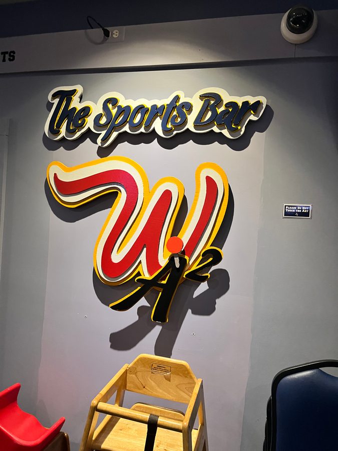 The W logo with the Sports Bar lettering on the wall above a high chair