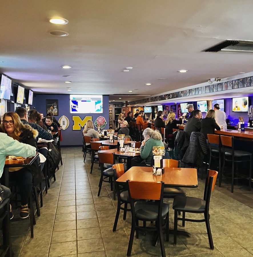 Busy dining room at The Sports Bar Westside with the Michigan M, football and Rose Bowl rose on the far wall
