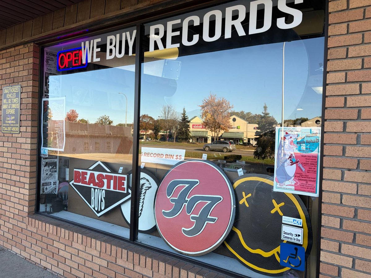 The Beastie Boys, Led Zeppelin Robert Plant symbol feather, Foo Fighters FF and Nirvana smiley hand-cut logos in the front window of Vinyl People Records